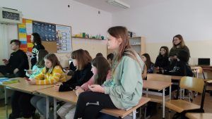grupa uczniów przy ławkach w trakcie konkursu