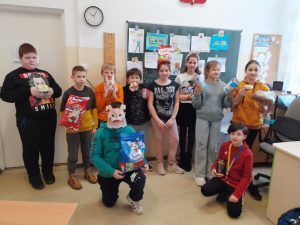 grupa uczniów w maskach zwierzątek i karmą dla schroniska