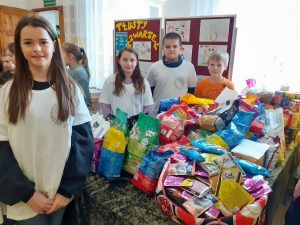 uczniowie przy zgromadzonych darach dla zwierząt