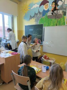 dwoje uczniów wraz z panią puszczają bańki mydlane