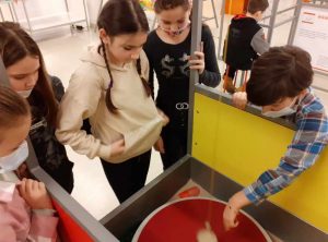 kilkoro uczniów obserwuje zjawisko fizyczne