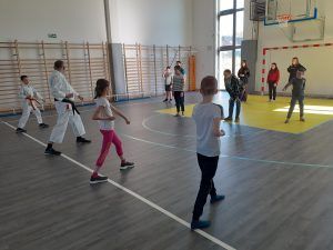 uczniowie szkoły karate prezentują ćwiczenia