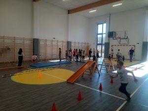 uczniowie na sali gimnastycznej podczas pokonywania toru przeszkód