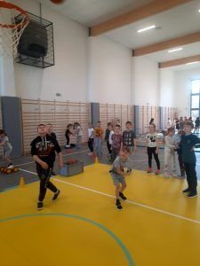 uczniowie na sali gimnastycznej podczas pokonywania toru przeszkód