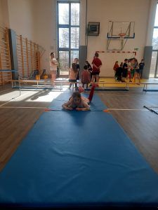 uczniowie na sali gimnastycznej podczas pokonywania toru przeszkód