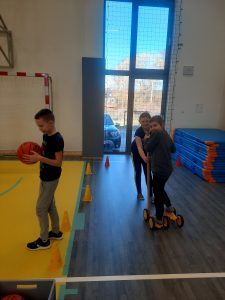 uczniowie na sali gimnastycznej podczas pokonywania toru przeszkód