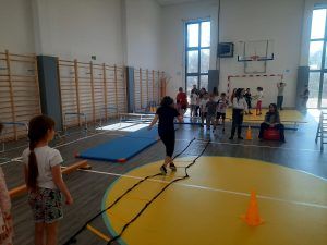 uczniowie na sali gimnastycznej podczas pokonywania toru przeszkód