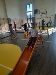 uczniowie na sali gimnastycznej podczas pokonywania toru przeszkód