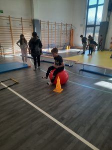 uczniowie na sali gimnastycznej podczas pokonywania toru przeszkód