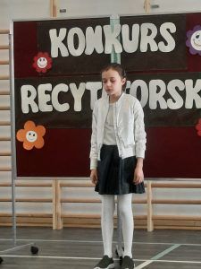 Uczeń recytuje wiersz podczas konkursu recytatorskiego