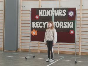 Uczeń recytuje wiersz podczas konkursu recytatorskiego