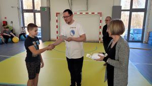 dyrektor gratuluje przedstawicielowi zwycięskiej klasy