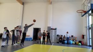 uczeń rzucający piłkę do kosza
