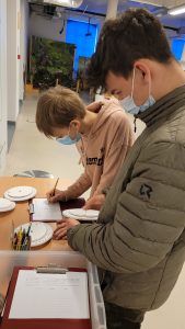 uczniowie rozwiązujący zadanie w grze terenowej