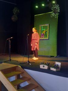 na zdjęciu uczennica recytuje wiersz na scenie