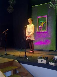 na zdjęciu uczennica recytuje wiersz na scenie