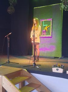 na zdjęciu uczennica recytuje wiersz na scenie