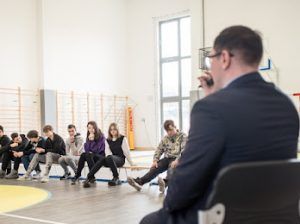 grupa uczniów przeprowadzająca wywiad z dyrektorem