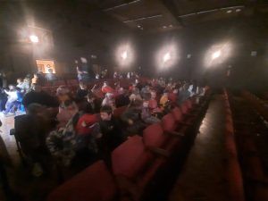 Uczniowie klas 1-3 siedzą na publiczności i oczekują na przedstawienie