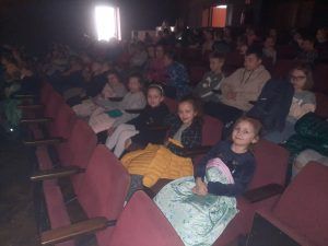 Uczniowie klas 1-3 siedzą na publiczności i oczekują na przedstawienie