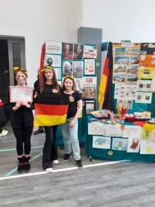 trzy uczennice przy stoisko prezentującym Niemcy