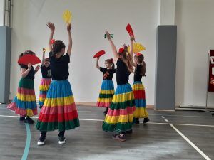 grupa dziewcząt w kolorowych spódnicach w tańcu