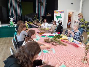 na zdjęciu uczniowie przygotowujący bibułę do tworzenia kwiatów