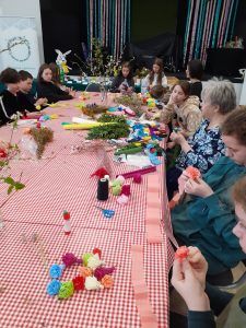 uczniowie robią kwiaty z kolorowej bibuły do palm