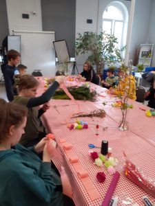 uczniowie robią kwiaty z kolorowej bibuły do palm