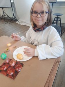 uczennica klasy trzeciej zdobi jajka woskiem