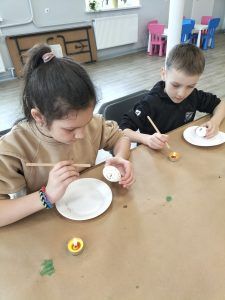 dzieci ozdabiają jajka woskiem