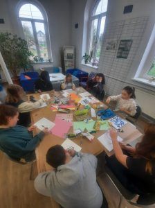 przy stole widać pracujące dzieci