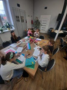 przy stole widać pracujące dzieci