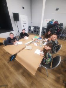 przy stole widać pracujące dzieci