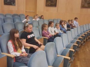 dzieci siedzą na fotelach w filharmonii