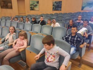 dzieci siedzą na fotelach w filharmonii