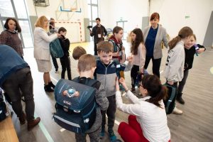 na zdjęciu dzieci z plecakami, które otrzymali w podarunku