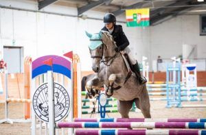 uczennica na koniu skaczącym przez płotki