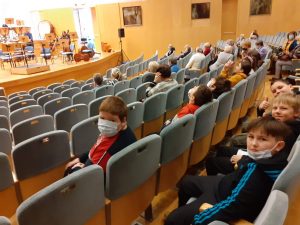 uczniowie słuchają próby orkiestry w filharmonii