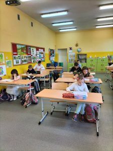 Uczniowie siedzący w ławkach podczas egzaminu trzecioklasisty