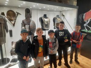 dzieci stoją przy muzealnych eksponatach