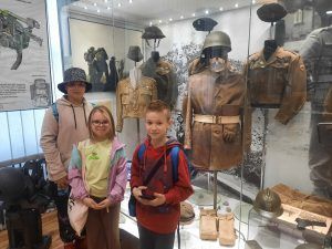dzieci stoją przy muzealnych eksponatach