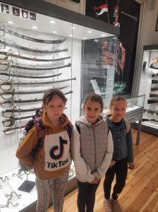 dzieci stoją przy muzealnych eksponatach