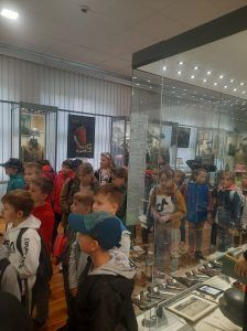 dzieci stoją przy muzealnych eksponatach
