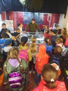 dzieci stoją przy muzealnych eksponatach