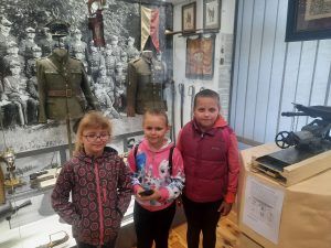 dzieci stoją przy muzealnych eksponatach