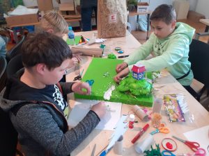 dwóch uczniów wykonujących prace plastyczne