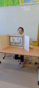 Dziewczynka prezentuje ilustracje do bajki 