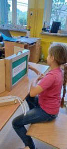 Uczennica klasy 1 czyta bajkę swoim kolegom i koleżankom