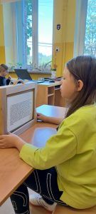 Uczennica klasy 3 czyta bajkę pierwszoklasistom